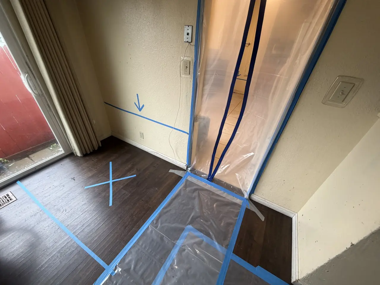 Containment sheeting and taped floor protection at a Richmond kitchen doorway