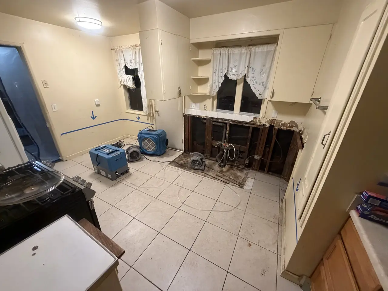 Kitchen with air movers and dehumidifiers running against the window wall