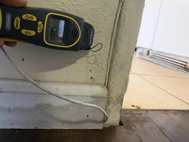 Moisture meter at the threshold between the kitchen tile and the dining-room laminate