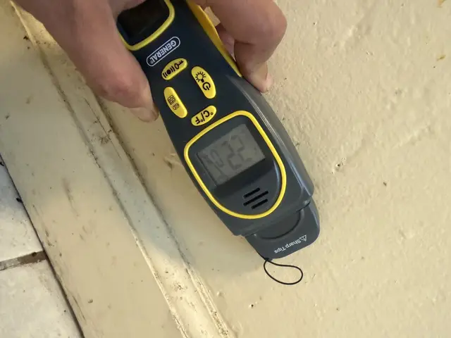 Moisture meter at the base of the kitchen window wall